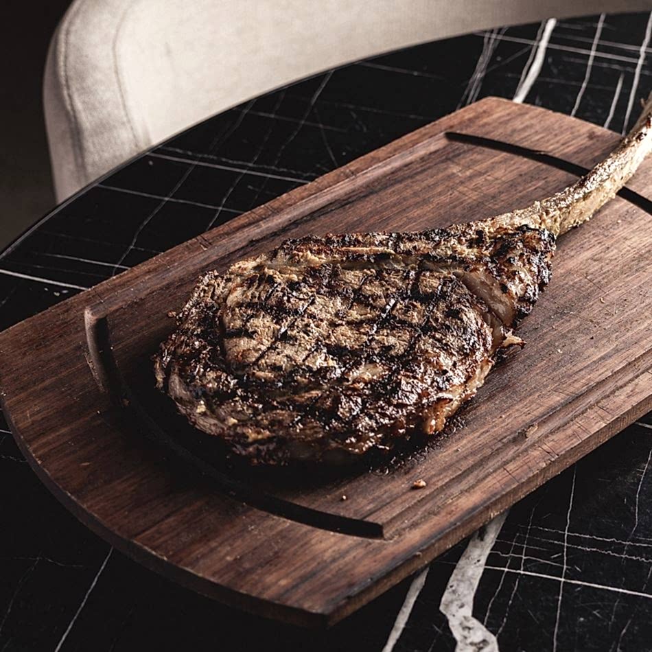 Hardal ile marine edilmiş Wagyu Tomahawk biftek, paylaşmak için ideal lezzetli bir et deneyimi sunar.