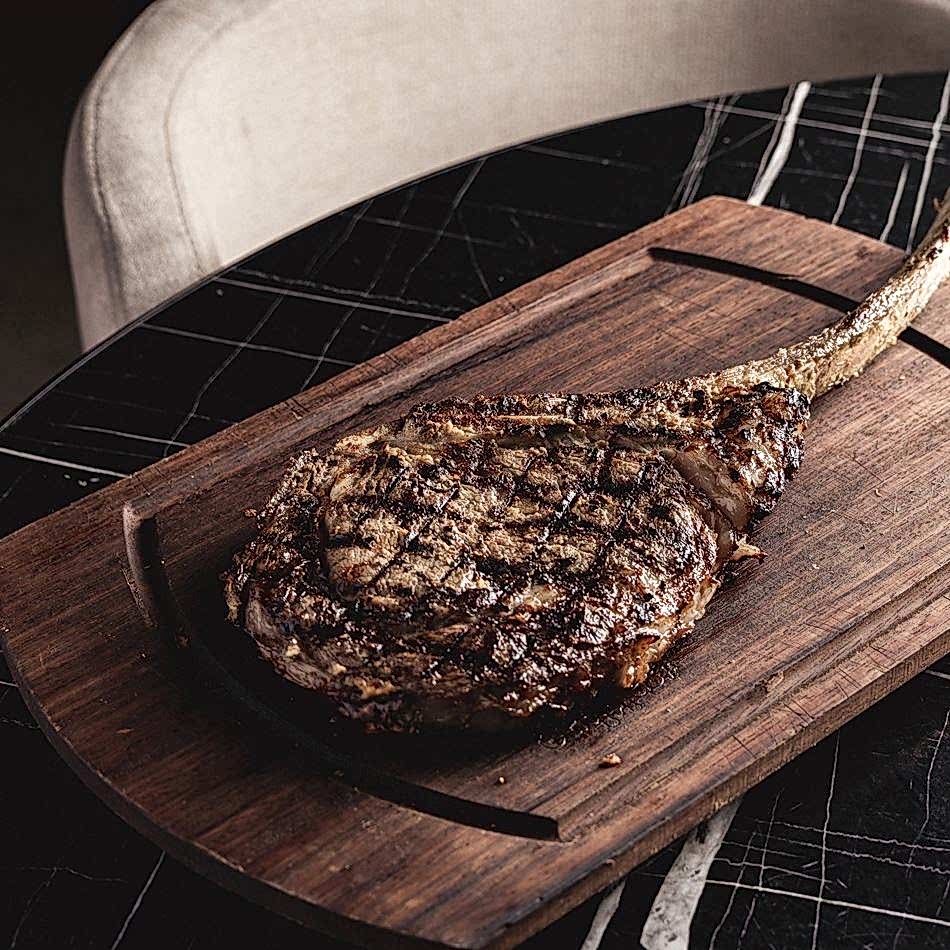 Hardal ile marine edilmiş Tomahawk biftek, paylaşmak için ideal lezzetli bir et deneyimi sunar.