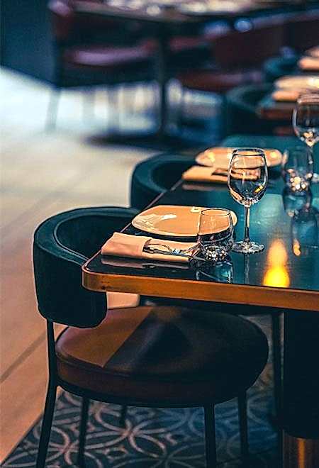 Nusr-Et New York Midtown'da özel yemek ve etkinlikler için şık bardaklar ve zarif bir ambiyansla hazırlanmış masa düzeni.