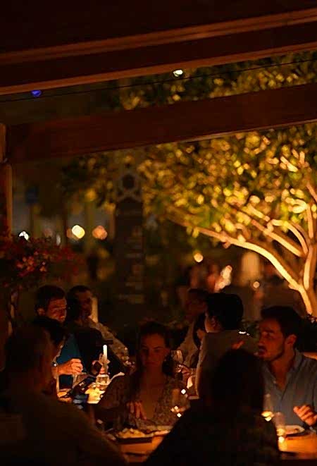 Nusr-Et Abu Dhabi’de lüks yemek deneyimi: Konuklar, açık alanda mum ışığı ve yeşil bitkiler eşliğinde samimi bir akşam yemeği keyfi yaşıyor