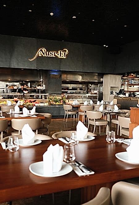 Nusr-Et Dubai’nin şık açık mutfak yemek alanı, şeflerin premium yemekleri hazırladığı lüks bir yemek deneyimi sunuyor.