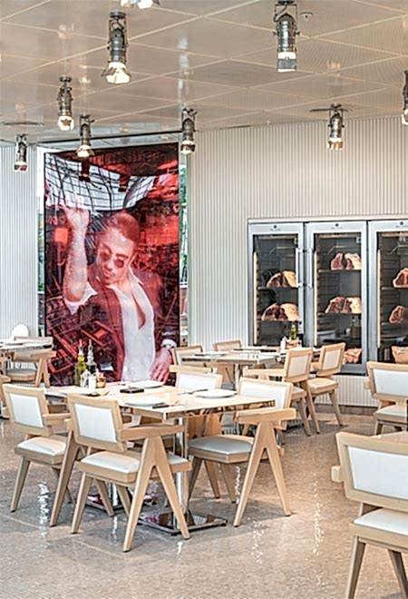 İstinye Park alışveriş merkezinde yer alan Nusr-Et İstinye’de açık ve ferah yemek alanı, minimalist beyaz sandalyeler ve masalarla rahat ve lüks bir yemek deneyimi sunuyor.