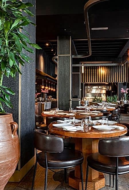Nusr-Et Miami’nin yuvarlak ahşap masalar ve modern dekorasyona sahip zarif iç mekanı, sofistike bir steakhouse atmosferi yaratıyor.