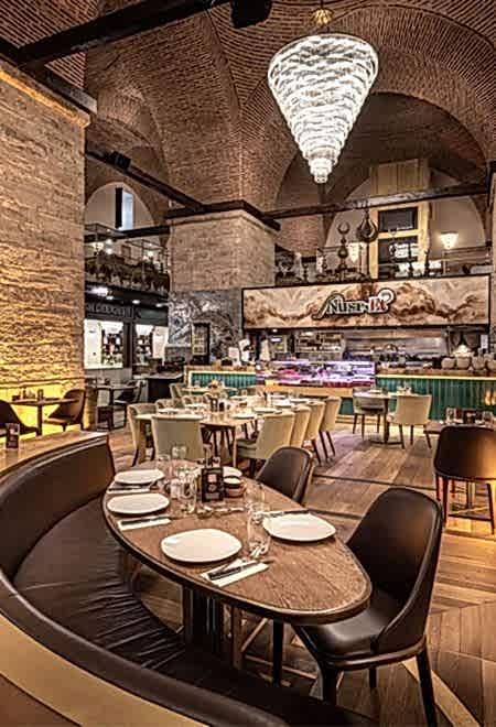 İstanbul Nusret Kapalı Çarşı'da kemerli tavan altında geniş merkezi yemek alanı, lüks ve eşsiz bir steakhouse atmosferi sunuyor.